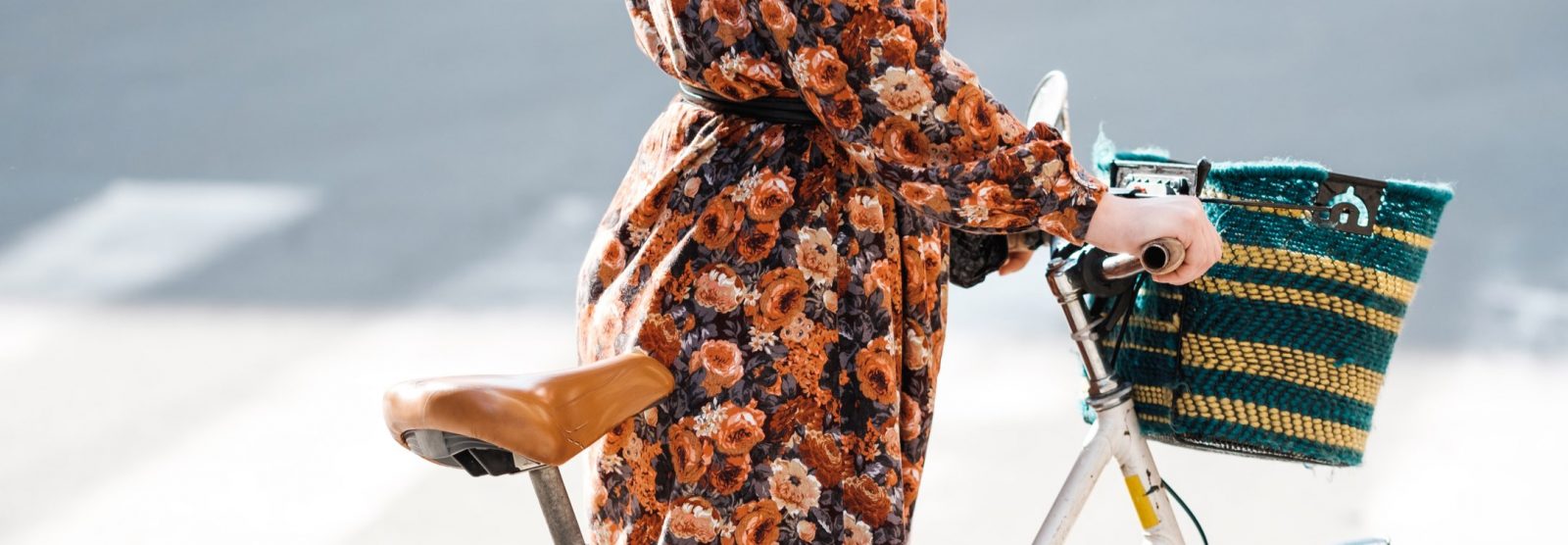 Person i blommig klänning som håller i cykel