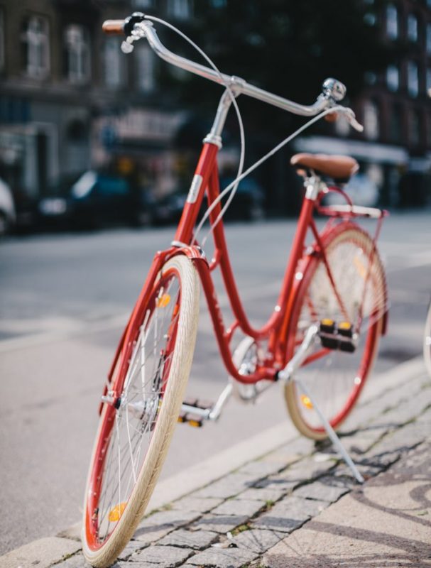 Röd cykel som står parkerad på gatan